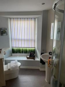 a bathroom with a tub and a toilet and a sink at The Thisle in Bristol