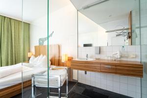 sypialnia z łóżkiem, umywalką i lustrem w obiekcie Gasthof OHR w mieście Eisenstadt