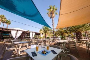 a restaurant with tables and chairs and palm trees at Estival Islantilla in Islantilla