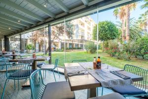 an outdoor patio with tables and chairs and windows at Estival Islantilla in Islantilla
