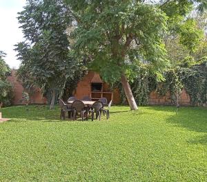 een tafel en stoelen in een tuin met een boom bij Casa Rural Orégano in Carmona