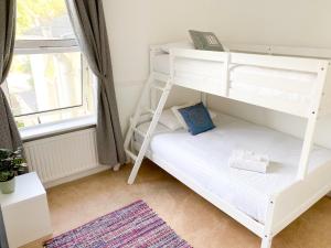トーキーにあるUpton House - Charming 4-bedroom home in Torquayの窓付きの客室の白い二段ベッド1台分です。