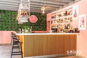 um bar com uma parede verde num restaurante em SOLEO Family Resort em Rewal