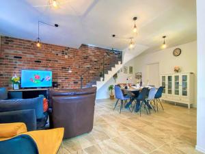 a living room with a table and chairs and a brick wall at Villa Vinka in Kozica