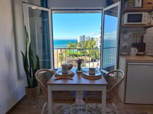a dining room with a table and a view of the ocean at Estudio Pies de Arena in Mijas Costa