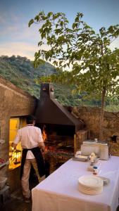 Um homem está em frente a um forno. em Casa Musicale em Pigna