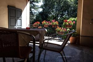 - une terrasse avec une table, des chaises et des fleurs dans l'établissement Villa Cantoni, à Gropello Cairoli
