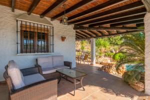een patio met een bank en een tafel bij El Chorro Villas Casa Buganvilla in El Chorro