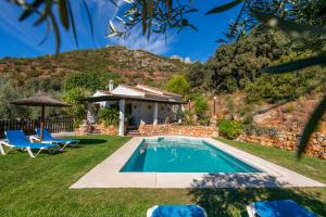 un patio trasero con piscina y una casa en El Chorro Villas Casa Buganvilla, en El Chorro