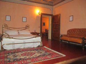 a bedroom with a bed and a couch and a rug at Villa Cantoni in Gropello Cairoli