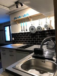 a kitchen with a sink and a counter with utensils at B&B Chalet Les Frenes in Chamonix-Mont-Blanc