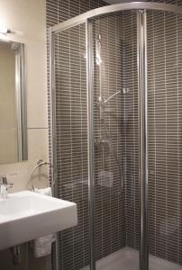 a bathroom with a glass shower with a sink at Hotel Restaurante El Corte in Casabermeja