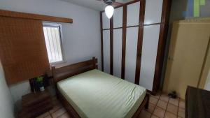 Habitación pequeña con cama y ventana en Apartamento confortável no centro de Guarapari, en Guarapari