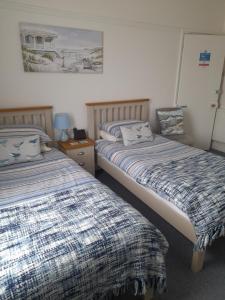 two beds sitting next to each other in a bedroom at South Rising Guest House in Poole