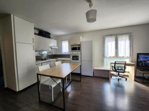 a kitchen with a wooden table and a dining room at Le pied à terre parisien - 77/94 in Pontault-Combault