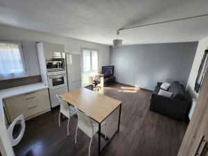 a kitchen and living room with a table and a couch at Le pied à terre parisien - 77/94 in Pontault-Combault +10 photos
