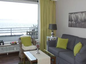 ein Wohnzimmer mit einem Sofa und einem Fenster in der Unterkunft Ferienwohnung "Fördekieker" in Ulstrupfeld