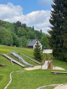 un parco giochi con scivoli in un campo con fienile di Hotel Waldeslust a Kurort Altenberg