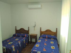 - une chambre avec 2 lits et une couette bleue dans l'établissement Magnífico chalet entre Sierra Nevada y Granada, à Dúdar