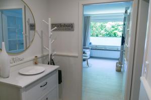 ein Bad mit einem Waschbecken und einem Spiegel in der Unterkunft Ferienwohnung Glücksburg 3322 in Ulstrupfeld