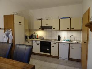 a kitchen with white cabinets and a stove top oven at Nord-Ostsee-Nest in Tarp