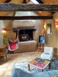 Lopérec的住宿－Chaleureuse maisonnette，带壁炉的客厅内的吊床