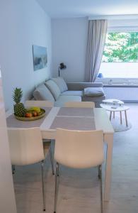 ein Wohnzimmer mit einem Tisch, Stühlen und einem Sofa in der Unterkunft Ferienwohnung Glücksburg 3322 in Ulstrupfeld