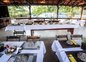 a dining room with white tables and chairs at Boutique Amazonia Hotel Restaurante in Alter do Chao