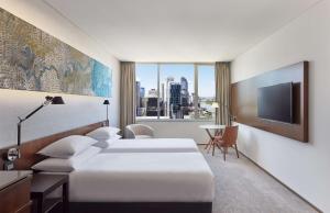 a hotel room with two beds and a tv at Hyatt Regency Brisbane in Brisbane