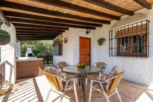 El Chorro Villas Casa Adelfa في إل شورو: فناء في الهواء الطلق مع طاولة وكراسي
