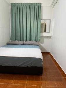 - un lit dans une chambre dotée d'un rideau vert dans l'établissement 2 Bedroom Port Dickson Seaview, à Port Dickson