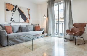 ein Wohnzimmer mit einem Sofa und einem Glastisch in der Unterkunft Lovely duplex with private parking near city center by REMS in Málaga