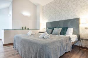 ein Schlafzimmer mit einem großen Bett mit Handtüchern darauf in der Unterkunft Lovely duplex with private parking near city center by REMS in Málaga