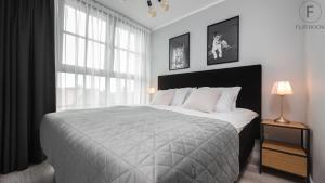 a bedroom with a large bed and a large window at Flatbook - City Center SPA Apartments Dwie Motlawy in Gdańsk