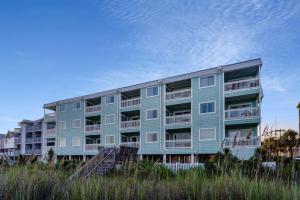 um edifício de apartamentos azul na praia em Sandpebble Beach Club Surfside Beach a Ramada by Wyndham em Myrtle Beach