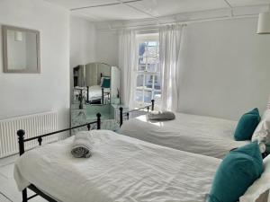um quarto branco com 2 camas e um espelho em The Deal Retreat em Kent