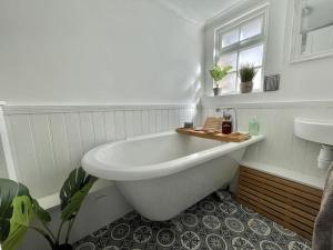 a white bathroom with a tub and a sink at The Deal Retreat in Kent