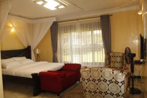 1 dormitorio con 1 cama y 1 silla roja en Terezina Guest House and Homes Pakwach, en Pakwach East