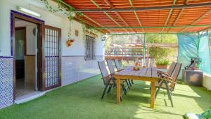 una mesa de madera y sillas en un patio en Casa Rural La Milla Verde Málaga - Campanillas by Ruralidays en Málaga