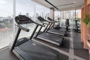 a row of treadmills in a gym with windows at Wyndham Garden Bangkok Sukhumvit 42 in Bangkok +92 photos