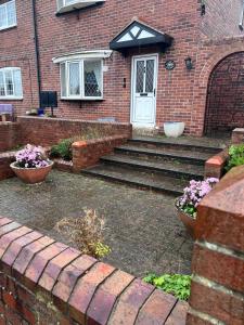 a brick house with stairs leading to a white door at Spacious 3 bedrooms house in Bolton Upon Dearne Up to 6 Guests! 
