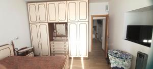1 dormitorio con un gran armario blanco con espejo en O Recanto, en Vallebona