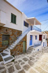 a white house with blue doors and stairs at Fully renovated 2 bedroom apartment near the restaurants and shops in Ioulida, Kea in Ioulis