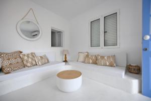 Camera bianca con panca con cuscini e specchio. di Fully renovated 2 bedroom apartment near the restaurants and shops in Ioulida, Kea a Ioulida