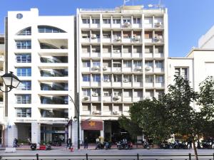 ein weißes Gebäude mit Motorrädern, die davor geparkt sind in der Unterkunft Athenian Apartment in the center with Jacuzzi in Athen