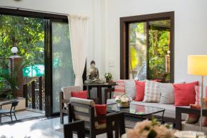 罗纳瓦拉SaffronStays Uno Crest, Lonavala - 4 BDR Artistically Decorated Villa Near Bhushi Dam的带沙发和桌子的客厅