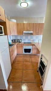 Una cocina con gabinetes de madera y un refrigerador blanco. en Ocean Golf, en San Miguel de Abona