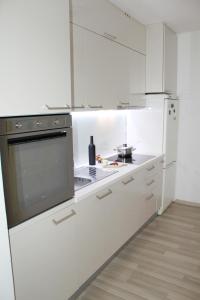 a white kitchen with a stove and a refrigerator at Sweet Home Zadar in Zadar