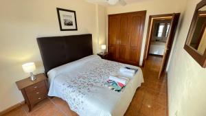 Un dormitorio pequeño con una cama y un armario de madera. en Ocean Golf, en San Miguel de Abona 10 fotos más