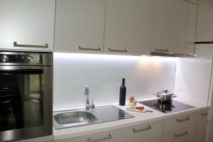 a white kitchen with a sink and a stove at Sweet Home Zadar in Zadar